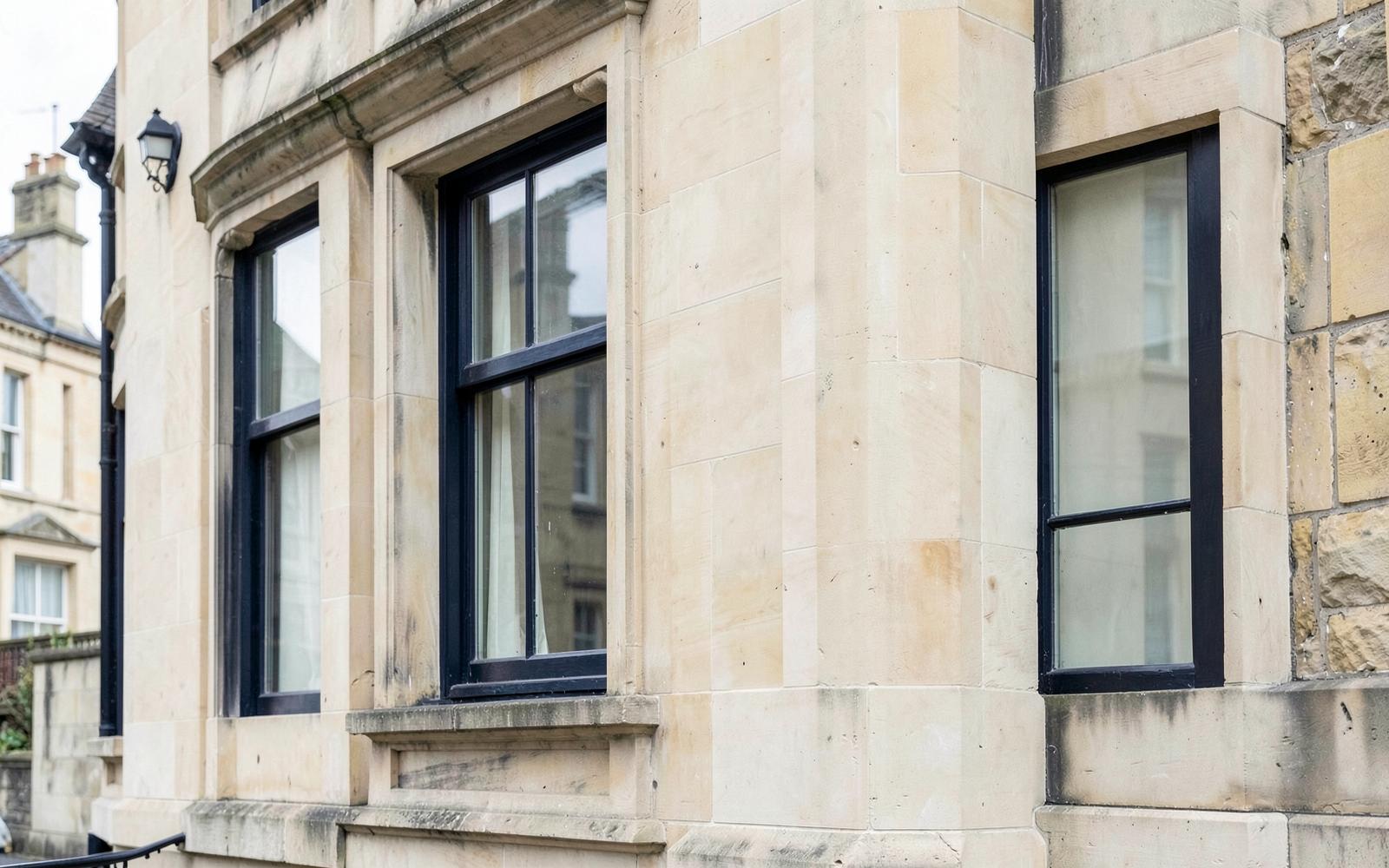 Detailed stone architecture and dark-framed windows on a London building